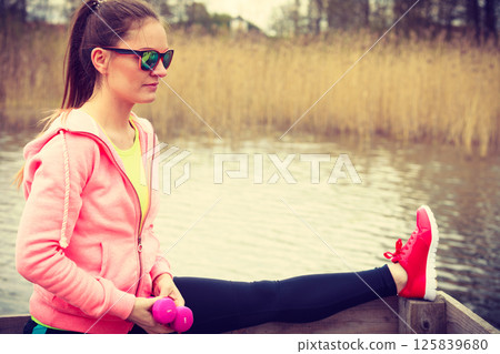 Girl training in sporty clothes on lake shore 125839680