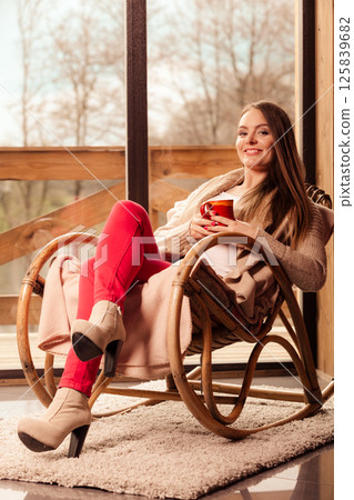 Woman sitting on chair relaxing at home 125839682