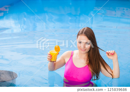 Girl with cocktail drink relaxing at swimming pool 125839686