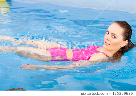 Beautiful woman swimming in pool Beautiful woman swimming in pool 125839689