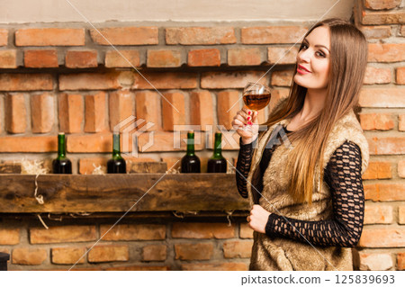 Woman tasting wine in rural cottage interior Woman tasting wine in rural cottage interior 125839693