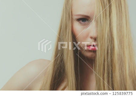 Sad girl covers her face with long hair Sad girl covers her face with long hair 125839775