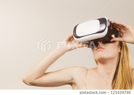 Girl wearing virtual reality goggles. 125839780