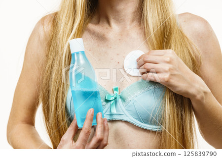 Woman acne on neckline cleaning skin with tonic Woman acne on neckline cleaning skin with tonic 125839790