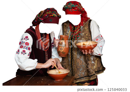 Women in Ukrainian national clothes holding wooden spoon jars plates cooking traditional dish kutia on Christmas Eve, isolated on white background Women in Ukrainian national clothes holding wooden spoon jars plates cooking traditional dish kutia on Christmas Eve, isolated on white background 125840033