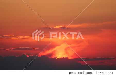 Fiery sunset, haze and clouds of a red tint. 125840275