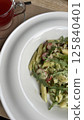 Indulge in delicious pasta made with fresh ingredients and enjoy a refreshing beverage alongside 125840401