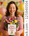 Mother Holding a Happy Mother's Day Card With a Colorful Flower Bouquet 125840504