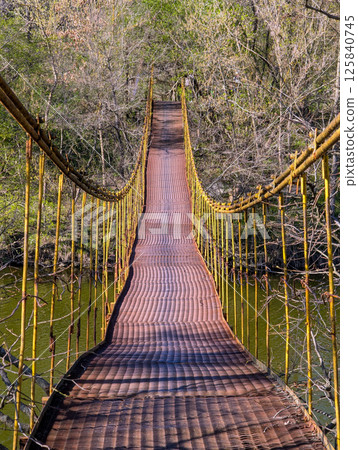 metal suspension bridge over the river metal suspension bridge over the river 125840745