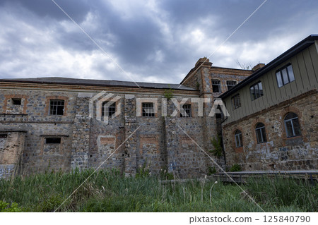 an old brick building that looks like a castle against a backdrop of storm clouds an old brick building that looks like a castle against a backdrop of storm clouds 125840790