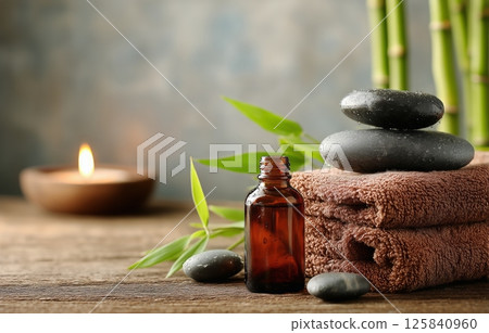 Relaxation Essentials With Stones, Aromatherapy Oil, and Soft Towels in a Serene Setting Relaxation Essentials With Stones, Aromatherapy Oil, and Soft Towels in a Serene Setting 125840960