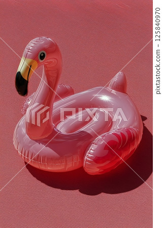 Colorful Inflatable Swan Float in Pink Pool Water on a Sunny Day During Summer 125840970