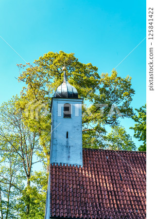 Church St.Clemens in Kranzberg near Freising, Bavaria with ancient graveyard and beautiful old wrought iron crosses Church St.Clemens in Kranzberg near Freising, Bavaria with ancient graveyard and beautiful old wrought iron crosses 125841422