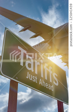 Tariffs Just Ahead Green Road Sign Against Clouds and Sky with Airplane Flying Above. Tariffs Just Ahead Green Road Sign Against Clouds and Sky with Airplane Flying Above. 125841439