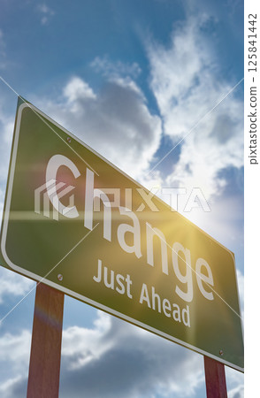 Change Just Ahead Green Road Sign Against a Blue Sky and Clouds. Change Just Ahead Green Road Sign Against a Blue Sky and Clouds. 125841442