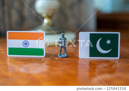 A tin soldier on the background of the flags of India and Pakistan. India Pakistan military conflict A tin soldier on the background of the flags of India and Pakistan. India Pakistan military conflict 125841558