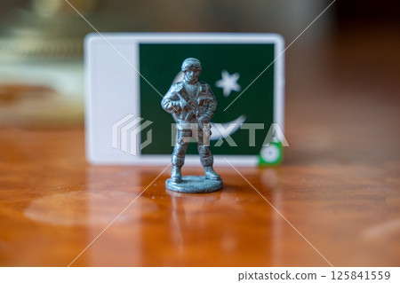A tin soldier on the background of the flag of Pakistan. India Pakistan military conflict 125841559