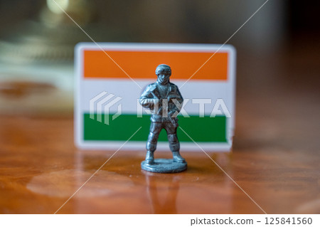 A tin soldier on the background of the Indian flag. India Pakistan military conflict 125841560