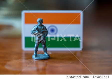 A tin soldier on the background of the Indian flag. India Pakistan military conflict 125841561