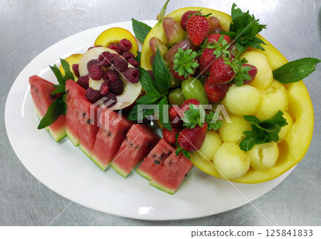 assorted ripe fruits and berries on a white plate assorted ripe fruits and berries on a white plate 125841833