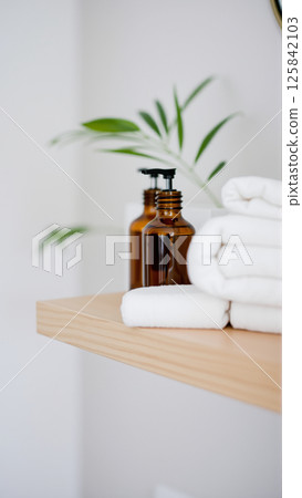 Spa treatment set, wooden shelf with neatly folded towels and dispensers for soap, cream, massage oil 125842103