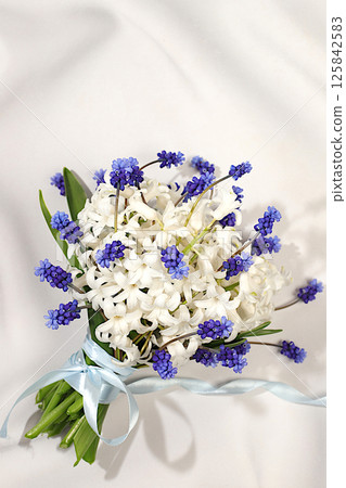Beautiful bouquet of white hyacinth and muscari. Abstract flower arrangement for screen and design template. Spring greeting card, elegant beauty concept, gift for loved ones, 125842583
