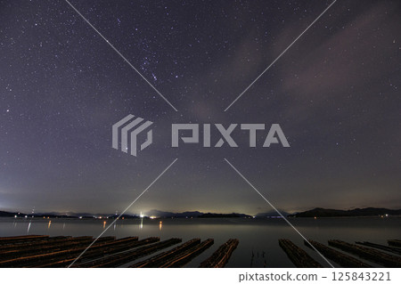 瀨戶內的秋季星空：獵戶座從海面升起，兩旁排列著牡蠣架 125843221