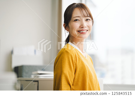 A youthful middle-aged career woman wearing yellow casual clothes 125843515