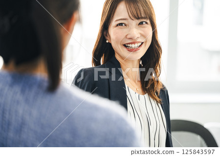 一位中年職業婦女與同事愉快地交談 125843597