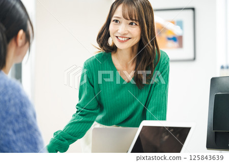 一位中年職業婦女在辦公室與同事交談 125843639