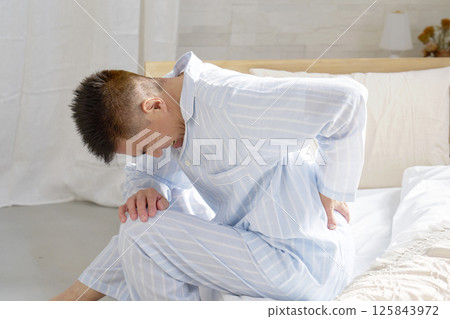 中年男子穿著睡衣，背部疼痛 125843972