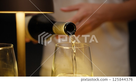 Waiter Pouring Expensive Wine Into The Glasses For The Customers  125844376