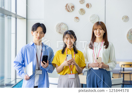 Businesswoman looking at her smartphone in the office lobby 125844578