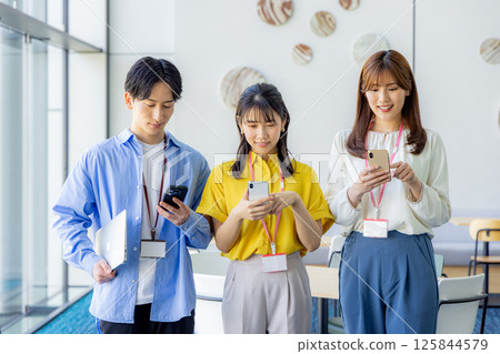 Businesswoman looking at her smartphone in the office lobby Businesswoman looking at her smartphone in the office lobby 125844579