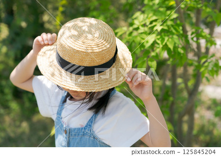 Girl wearing a straw hat 125845204