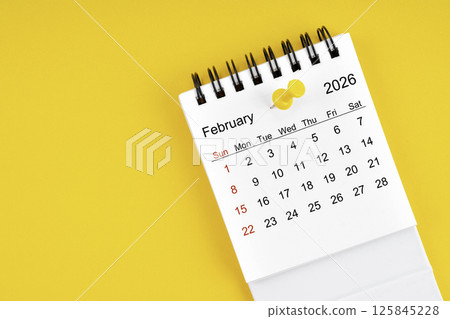 February 2026 Monthly desk calendar for 2026 year with thumbtack on yellow background. 125845228