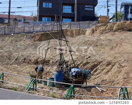 Workers surveying a construction site for a residential area 125845263