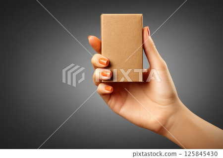 Hand Holding Simple Brown Packaging Sleeve Mockup for Book or Small Product Display 125845430