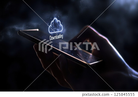 Close Up of Hand Holding Smartphone Displaying Downloading Icon Against Dark Background 125845555
