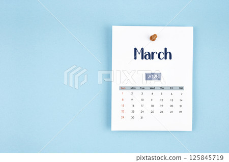 March 2026 calendar page with push pin on blue background. 125845719