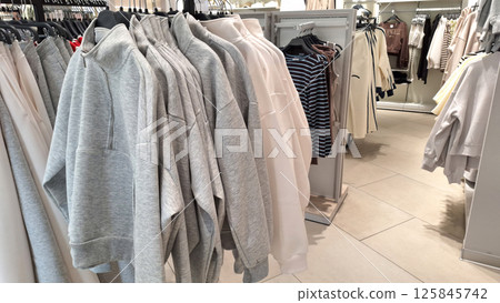 Casual clothing display with hoodies, sweaters, and coats in a retail store Casual clothing display with hoodies, sweaters, and coats in a retail store 125845742