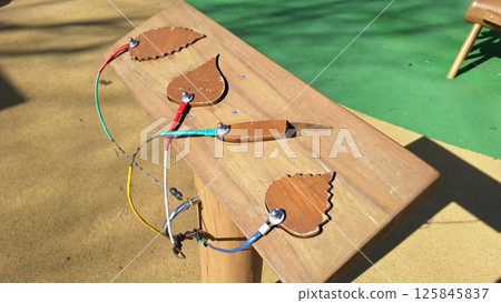 Interactive wooden leaf panel in playground for children's outdoor stem learning Interactive wooden leaf panel in playground for children's outdoor stem learning 125845837