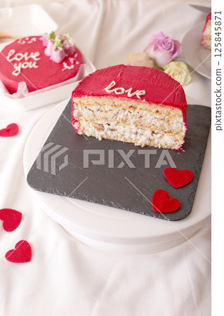 Red valentine's cake slice with heart decorations on slate plate Red valentine's cake slice with heart decorations on slate plate 125845871
