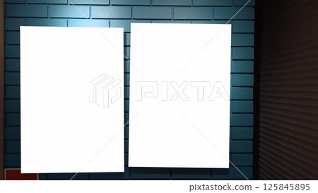Two blank vertical posters on blue brick wall in dimly lit interior 125845895