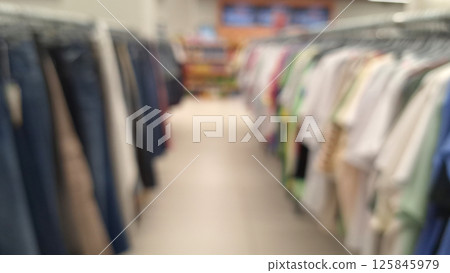 Blurred view of clothing aisle in store with various apparel on racks Blurred view of clothing aisle in store with various apparel on racks 125845979