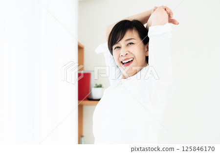 A woman stretching at the window side A woman stretching at the window side 125846170