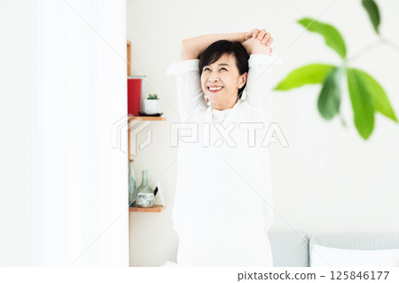 A woman stretching at the window side A woman stretching at the window side 125846177