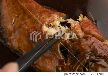 Lifting boiled red snapper with chopsticks Lifting boiled red snapper with chopsticks 125847003