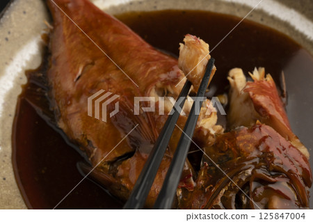 用筷子夾起煮熟的紅鯛魚 用筷子夾起煮熟的紅鯛魚 125847004