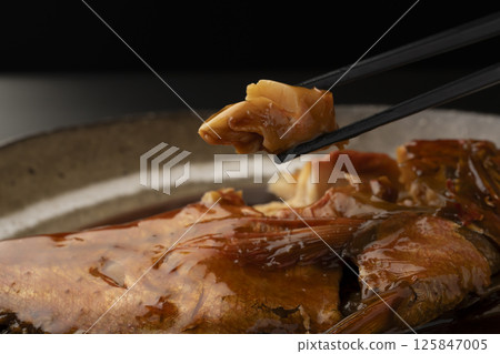 Lifting boiled red snapper with chopsticks 125847005